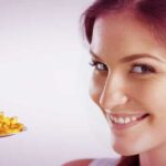 Girl smiling taking a spoonful of natural supplements